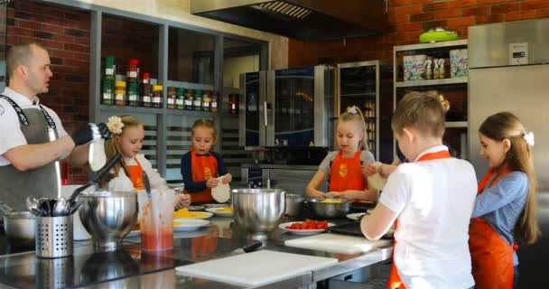 Дети учатся у шеф-повара, как делать тесто — стоковое видео