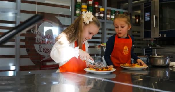 Девушки режут пиццу специальным ножом — стоковое видео