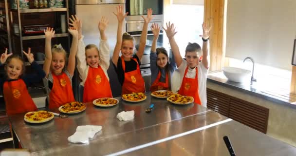 Happy children are photographed in the restaurant kitchen after making pizza with their own hands — Stock Video