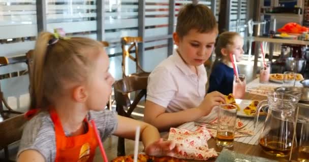 Niños en la mesa festiva comunicarse y comer — Vídeos de Stock