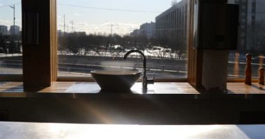 Pencerenin kenarındaki lavabo gün ışığında parlıyor.