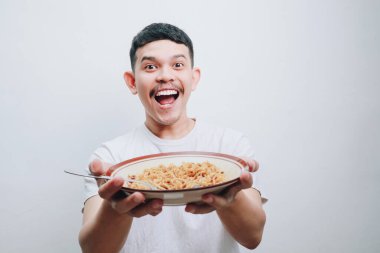 Neşeli bir adam bir kase iştah açıcı erişte sunar. Görüntü saf neşeyi ve enfes bir yemek anını yakalar..