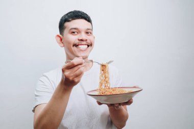 Neşeli bir adam bir tabak erişteden zevk alır ve mutluluğu gösterir..