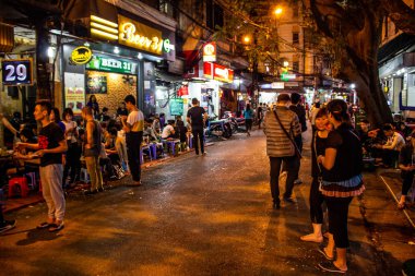 Hanoi, Vietnam - 15 Mart 2018: Hanoi barlarda ile popüler bir sokakta duran gençler
