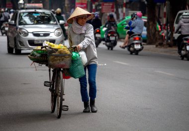 Hanoi, Vietnam - 16 Mart 2018: meyve onun bisiklet ile yolda satış üst düzey Bayan