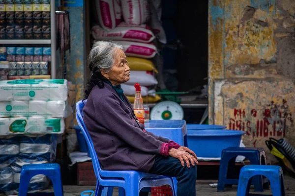 Hanoi, Vietnam - 16 Mart 2018: caddenin onun salonu önünde oturan üst düzey Vietnamca kadın