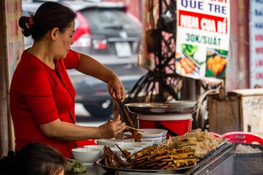 Hanoi, Vietnam - 16 Mart 2018: et sokak bir restoranda yemek kadın