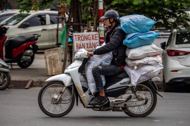 Hanoi, Vietnam - 16 Mart 2018: adam ağır bagaj ile yüklenen bir scooter sürme