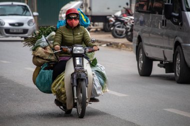 Hanoi, Vietnam - 16 Mart 2018: Bagaj onun motosiklet üzerinde ağır bir yük taşıma yerel kadın