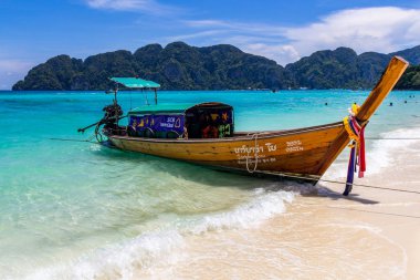 Koh Phi Phi, Tayland - 7 Mayıs 2018: Duru turkuaz suları ile kumlu bir plaj üzerinde uzun kuyruk yerel tekneler demirli