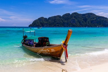 Koh Phi Phi, Tayland - 7 Mayıs 2018: Duru turkuaz suları ile kumlu bir plaj üzerinde uzun kuyruk yerel tekneler demirli