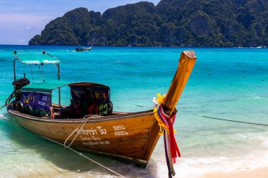 Koh Phi Phi, Tayland - 7 Mayıs 2018: Duru turkuaz suları ile kumlu bir plaj üzerinde uzun kuyruk yerel tekneler demirli