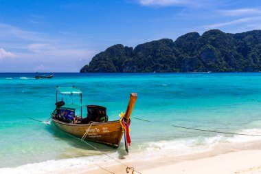 Koh Phi Phi, Tayland - 7 Mayıs 2018: Duru turkuaz suları ile kumlu bir plaj üzerinde uzun kuyruk yerel tekneler demirli