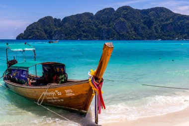 Koh Phi Phi, Tayland - 7 Mayıs 2018: Duru turkuaz suları ile kumlu bir plaj üzerinde uzun kuyruk yerel tekneler demirli