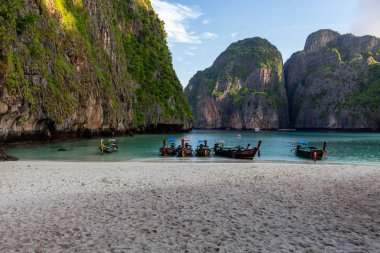 Koh Phi Phi, Tayland - 9 Mayıs 2018: Güneş doğarken Maya Bay sants beyaz uzun kuyruk ahşap tekneler demirli