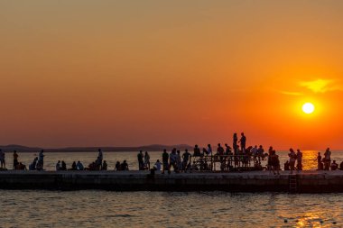 Zadar, Hırvatistan - 24 Temmuz 2018: insanlar bir dock eski şehir Zadar içinde etkileyici bir gün batımını izlemek