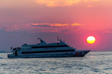 Zadar, Hırvatistan - 24 Temmuz 2018: Zadar içinde gün batımında yolcu kavuşturan tekne