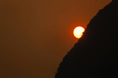 Sezon içinde Kuzey Laos yanma sırasında kırmızı günbatımı sisli kalker tepe üzerinde
