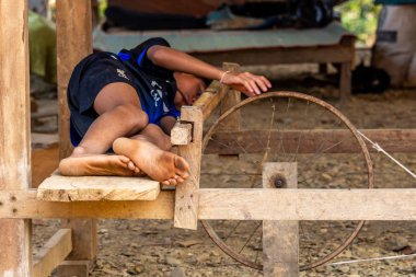 Ban Na, Laos - 10 Nisan 2018: Kuzey Laos uzak bir köyde basit bir tekerlek ile oynayan etnik azınlık çocuk