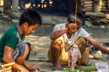 Bachong Nay,, Laos - 10 Nisan 2018: Bir topluluk öğle yemeği için çiğ et pişirme Kuzey Laos uzak bir bölgede etnik bir topluluk üyeleri