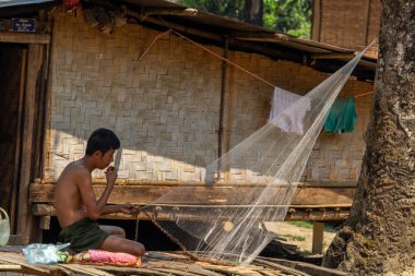 Bachong Nay,, Laos - 10 Nisan 2018: kendi bambu evin önünde bir net tamir bir etnik azınlık Köyü ile ilgili yerel adam