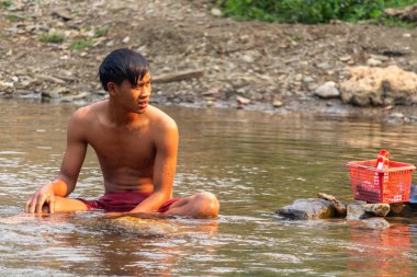 Ban Na, Laos - 10 Nisan 2018: topluluk birlikte Laos derin counstryside içinde bir nehir banyoda genç adam