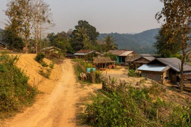 Ban Na, Laos - 10 Nisan 2018: Asfalt yol ve en uzak etnik köylerinden Laos yeşille çevrili evleri