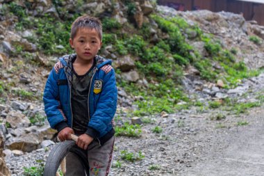 Ha Giang, Vietnam - 17 Mart 2018: Kuzey Vietnam uzak bir dağlık alanda bir lastik ile oynarken Hmong etnik azınlık çocuktan