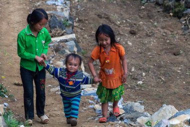 Ha Giang, Vietnam - 17 Mart 2018: Kuzey Vietnam dağlarında bir köyde asfalt bir yolda yürürken Hmong etnik azınlık çocuk
