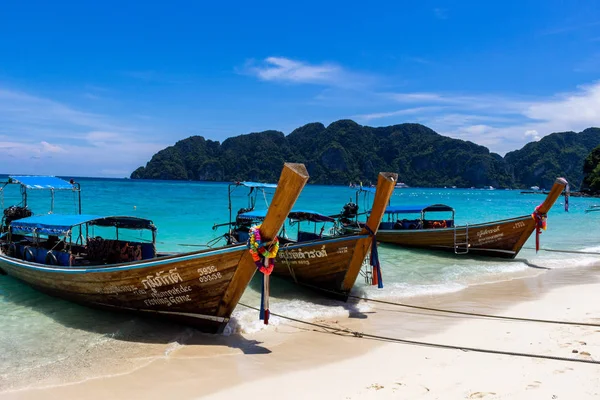 Koh Phi Phi, Tayland - 7 Mayıs 2018: Duru turkuaz suları ile kumlu bir plaj üzerinde uzun kuyruk yerel tekneler demirli