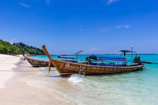 Koh Phi Phi, Tayland - 7 Mayıs 2018: Duru turkuaz suları ile kumlu bir plaj üzerinde uzun kuyruk yerel tekneler demirli