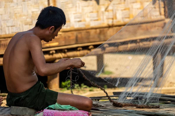 Bachong Nay,, Laos - 10 Nisan 2018: balık ağı kendi bambu evin önünde tamir bir etnik azınlık Köyü ile ilgili yerel adam
