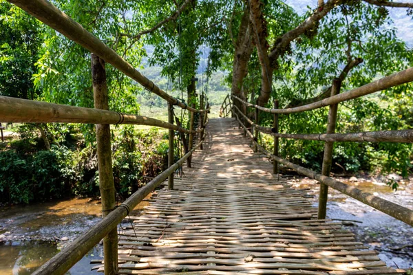 Muong Ngoi, Laos - 10 Nisan 2018: Laos yeşil kırsalında bir nehir ahşap köprü