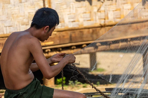 Bachong Nay,, Laos - 10 Nisan 2018: balık ağı kendi bambu evin önünde tamir bir etnik azınlık Köyü ile ilgili yerel adam