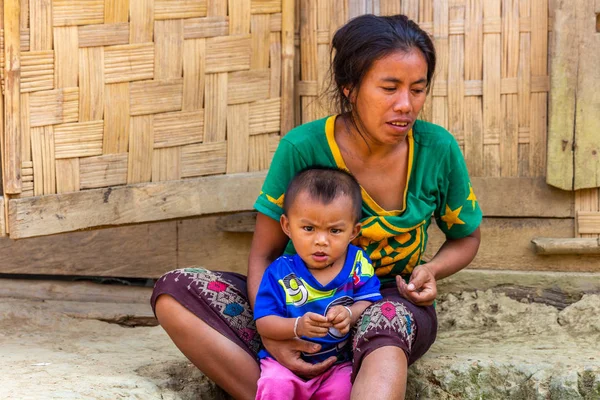 bachong Nay,, Laos - 10 Nisan 2018: anne ve Laos bir uzak köy bambu evin önünde oturan bir etnik azınlık kızgın çocuk