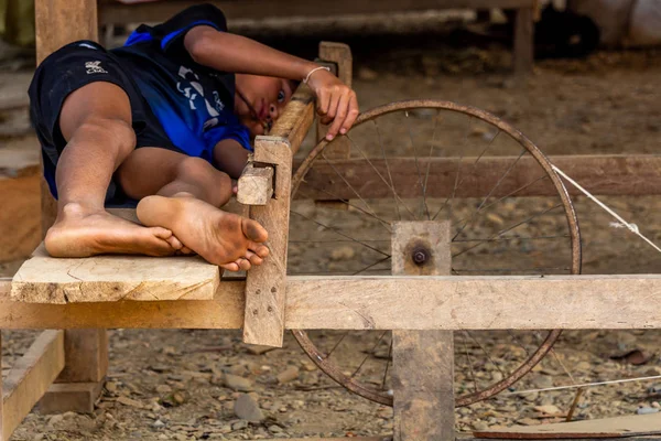 Ban Na, Laos - 10 Nisan 2018: Kuzey Laos uzak bir köyde basit bir tekerlek ile oynayan etnik azınlık çocuk