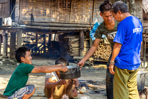 Бачонг Ной, Лаос - 10 апреля 2018 года: Члены этнической общины в отдаленном районе северного Лаоса готовят сырое мясо для общественного обеда
