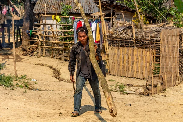Bachong Nay,, Laos - 10 Nisan 2018: Kuzey Laos uzak bir köyde asfalt bir yolda bir ahşap taşıma bir etnik azınlık grubu ile ilgili adam