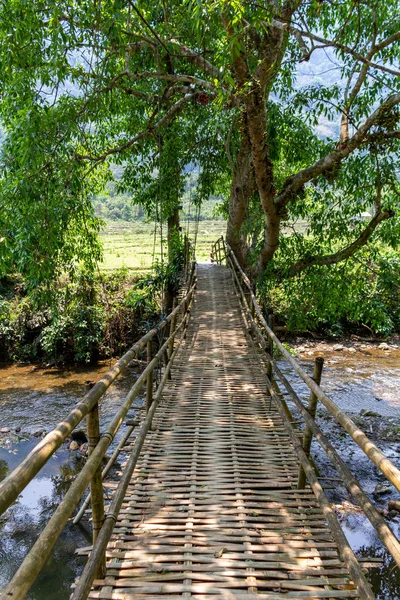 Muong Ngoi, Laos - 10 Nisan 2018: Laos yeşil kırsalında bir nehir ahşap köprü