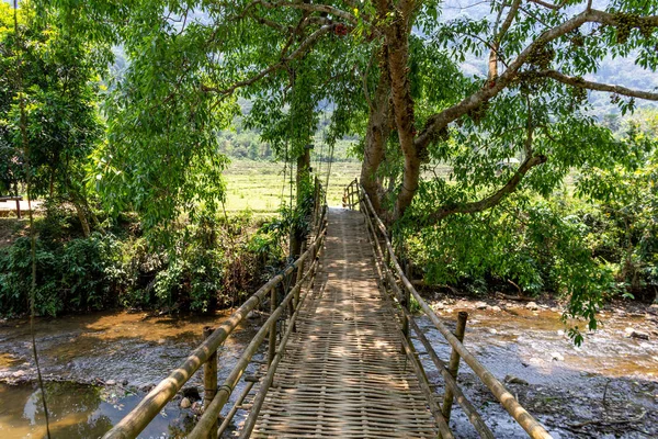 Muong Ngoi, Laos - 10 Nisan 2018: Laos yeşil kırsalında bir nehir ahşap köprü