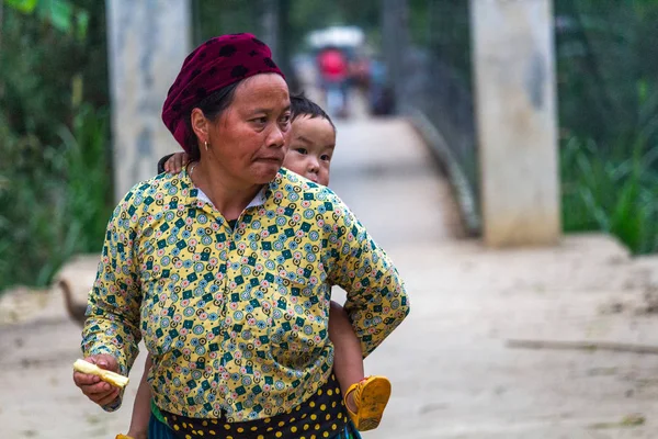 Ha Giang, Vietnam - 17 Mart 2018: bir çocuk sırtında taşıyan Hmong etnik azınlık gelen üst düzey kadın