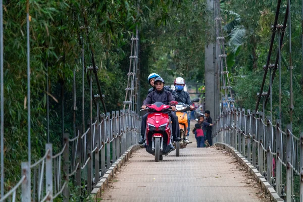 Ha Giang, Vietnam - 17 Mart 2018: motosiklet ve Kuzey Vietnam orman çevrili bir metal köprüyü geçtikten çocuk