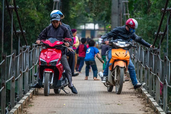 Ha Giang, Vietnam - 17 Mart 2018: motosiklet ve Kuzey Vietnam orman çevrili bir metal köprüyü geçtikten çocuk