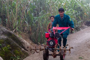 Ha Giang, Vietnam - 17 Mart 2018: baba ve çocuk Kuzey Vietnam sisli karstik dağlarında bir tarım aracı ile