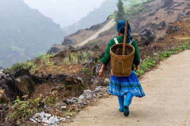 Ha Giang, Vietnam - 18 Mart 2018: Kuzey Vietnam dağlarında bir yolda yürürken Hmong etnik azınlık kadından