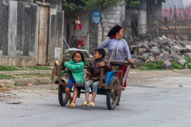 Ha Giang, Vietnam - 18 Mart 2018: el ile bir kamyon Kuzey Vietnam uzak kırsal alanda iki çocuk taşıyan anne