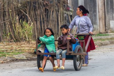 Ha Giang, Vietnam - 18 Mart 2018: el ile bir kamyon Kuzey Vietnam uzak kırsal alanda iki çocuk taşıyan anne