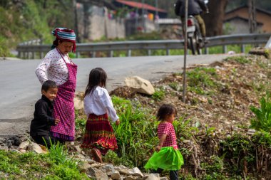 Ha Giang, Vietnam - 18 Mart 2018: aile yakınlarında dağlara Kuzey Vietnam bir sokakta yürürken Hmong etnik azınlık üzerinden