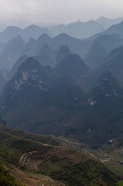 Ha Giang, Vietnam - 18 Mart 2018: doğal Vadisi ile çevrili tepeleri ve Vietnam sisli dağlar pirinç terasları