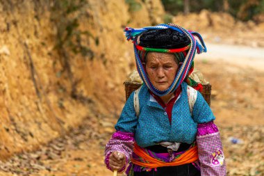 Ha Giang, Vietnam - 18 Mart 2018: Kuzey Vietnam tarım alanları yakın tozlu bir yolda yürüyen kadın